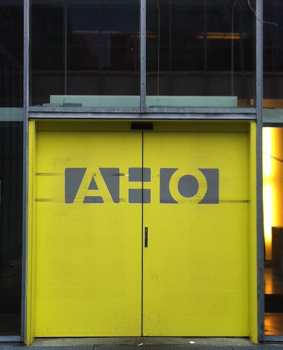 Inngangen til Arkitektur- og designhøgskolen i Oslo med skilt og logo.